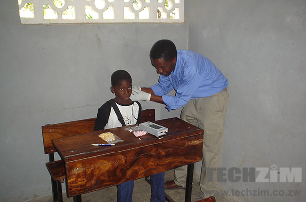 Tendekayi Katsiga working with a hearing impaired child.  