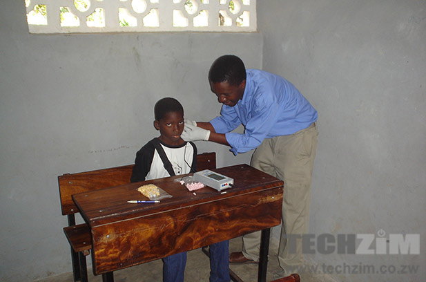 Tendekayi Katsiga working with a hearing impaired child.