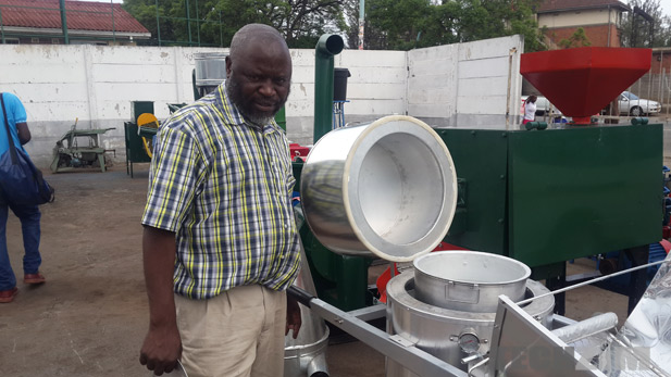 Solomon Marimo stands next to his solar stove