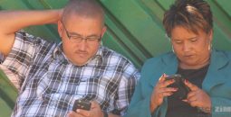 couple-holding-phone-reading-news