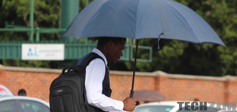 Man holding umbrella walking.