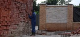 Builder next to bricks near a wall